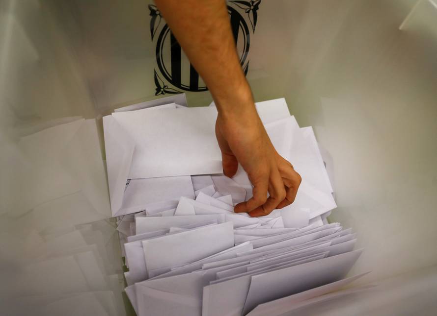 Poll workers count ballots after polls closed at a polling station for the banned independence referendum in Barcelona