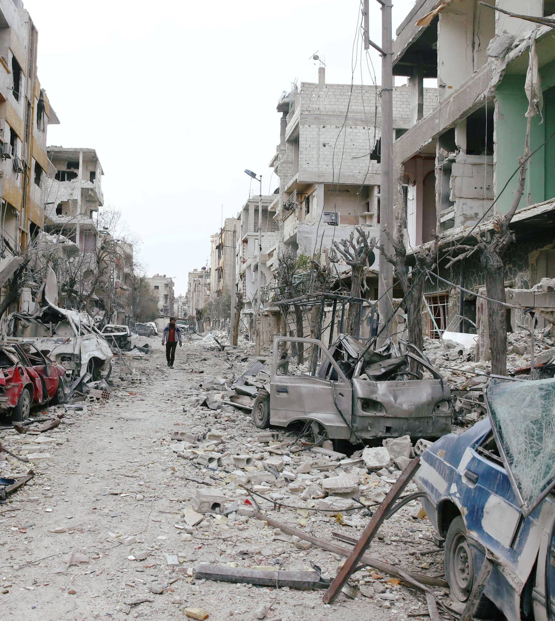 Damaged cars and buildings are seen in the besieged town of Douma, Eastern Ghouta, Damascus