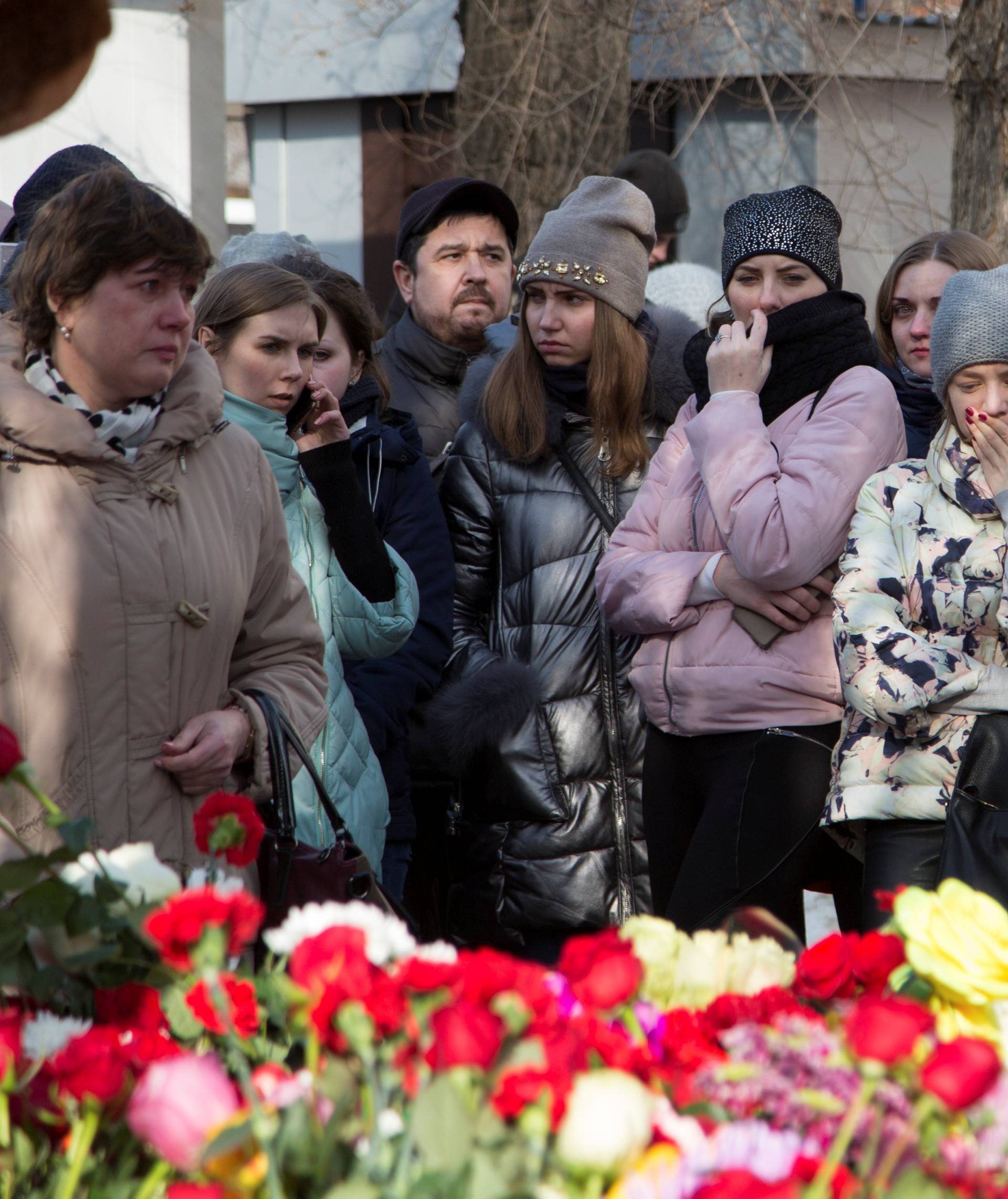 People mourn the victims of a shopping mall fire at a makeshift memorial in the Siberian city of Kemerovo