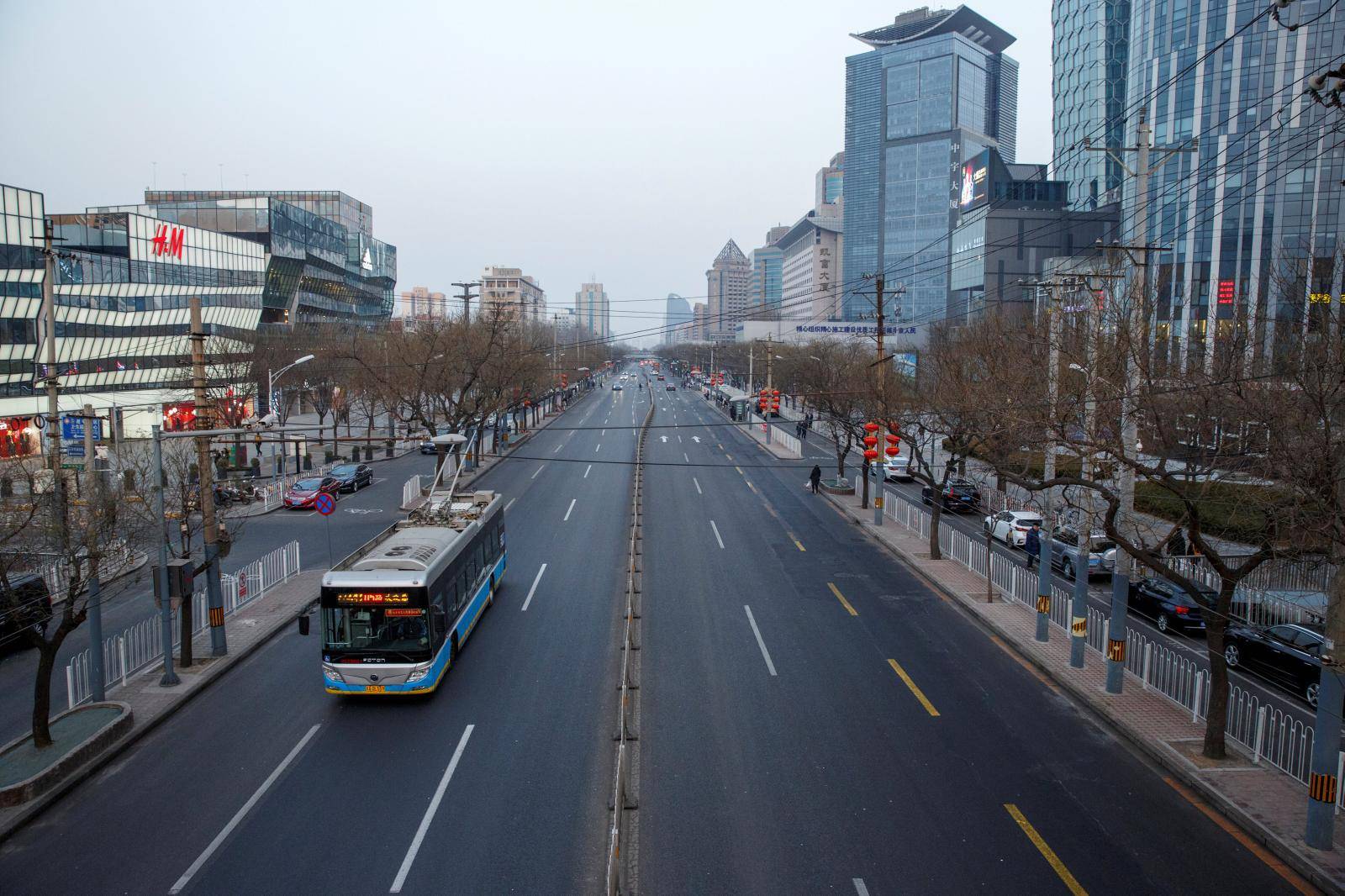 FILE PHOTO: A electric bus goes on a usually busy main road in the Sanlitun shopping district after the city emptied ahead of Chinese New Year in Beijing