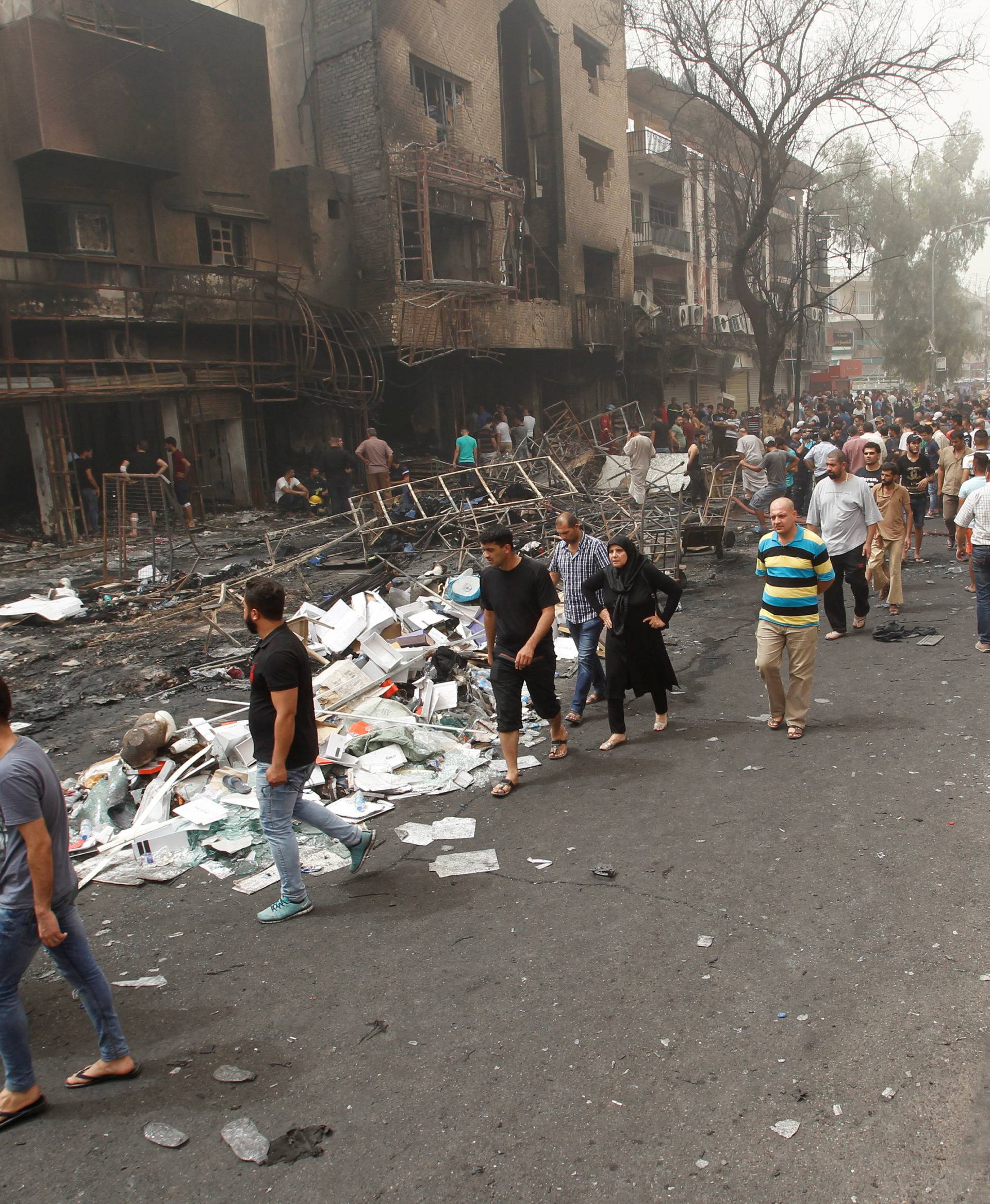 Iraqi security forces and civilians gather at the site after a suicide car bomb occurred in the Karrada shopping area in Baghdad, Iraq