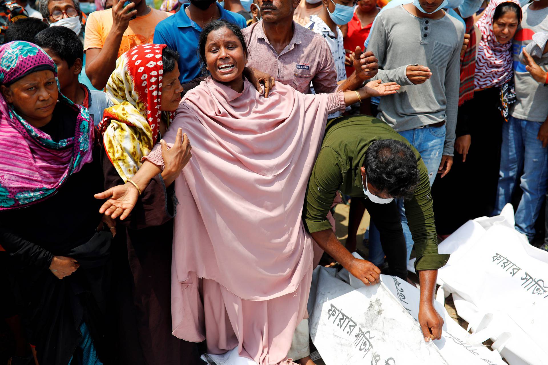 Relatives mourn after several people died due to the collision and sinking of a ferry at the Shitalakhsyaa River in Narayanganj