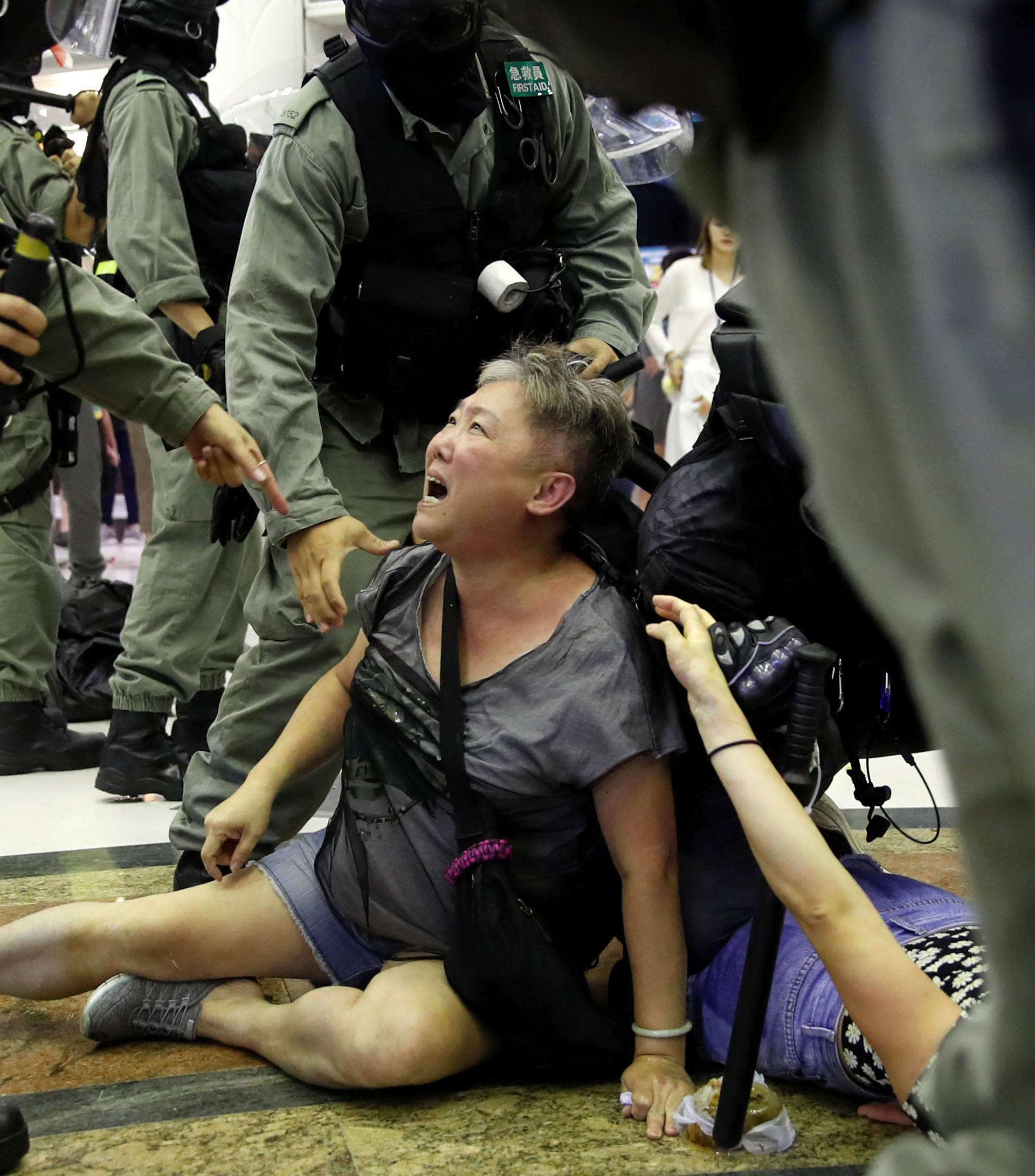 Riot police detain a woman during a protest at a shopping mall in Tai Po, Hong Kong