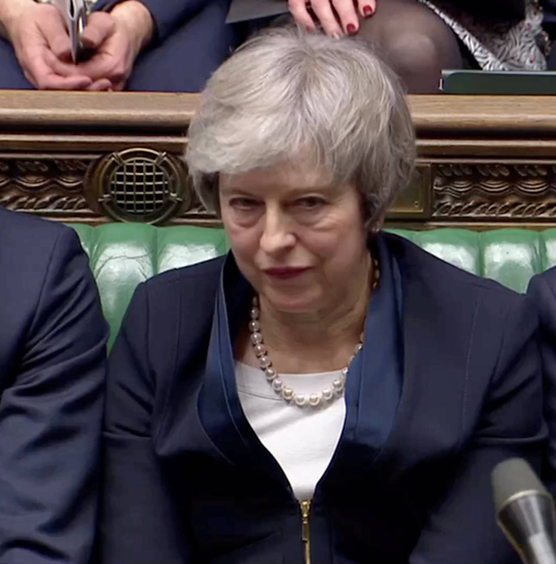 Prime Minister Theresa May sits down in Parliament after the vote on May's Brexit deal, in London