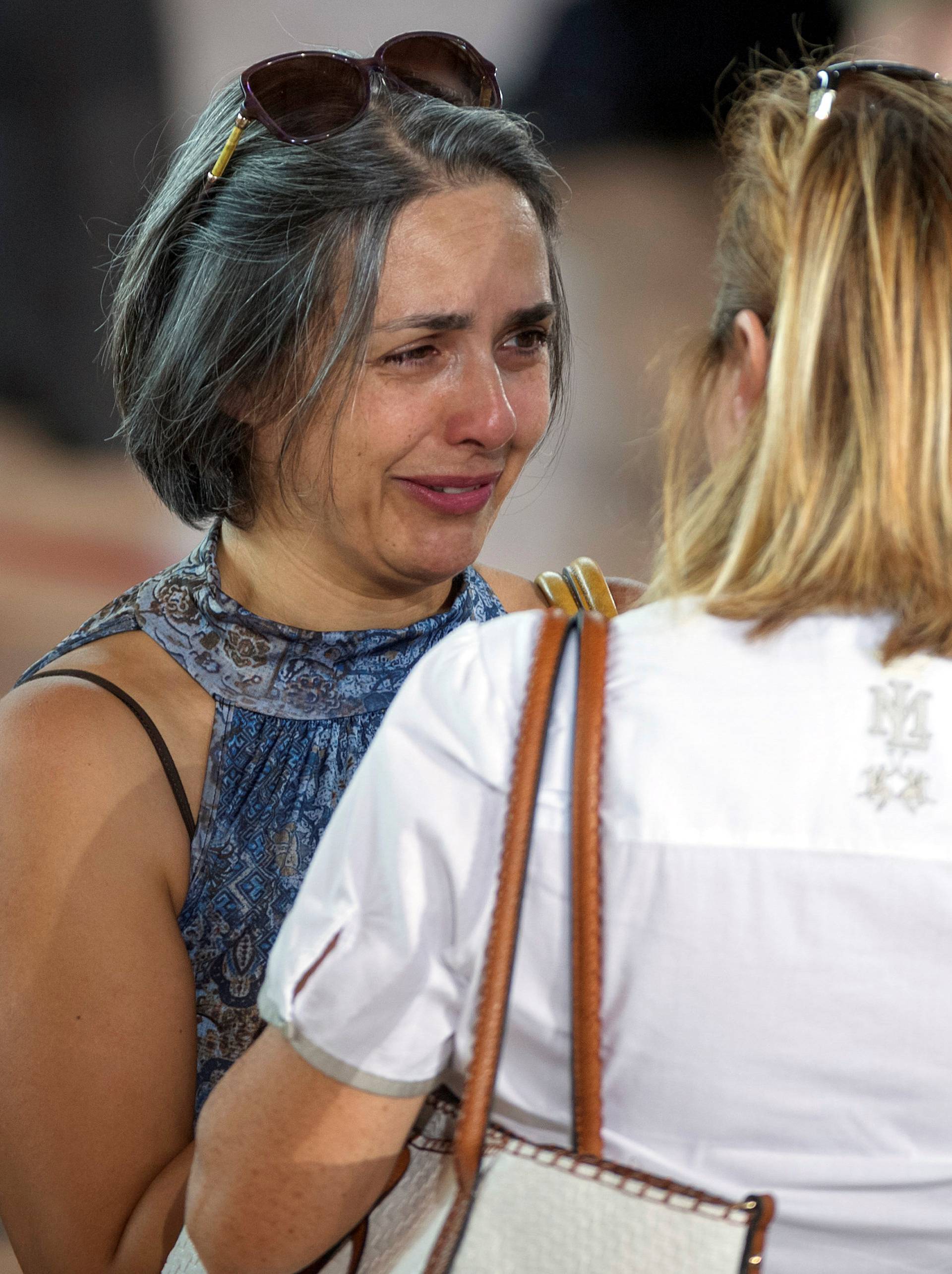 A woman cries after a funeral service for victims of the earthquake inside a gym in Ascoli Piceno