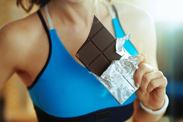 Closeup,On,Young,Woman,In,Fitness,Clothes,With,Chocolate,Bar