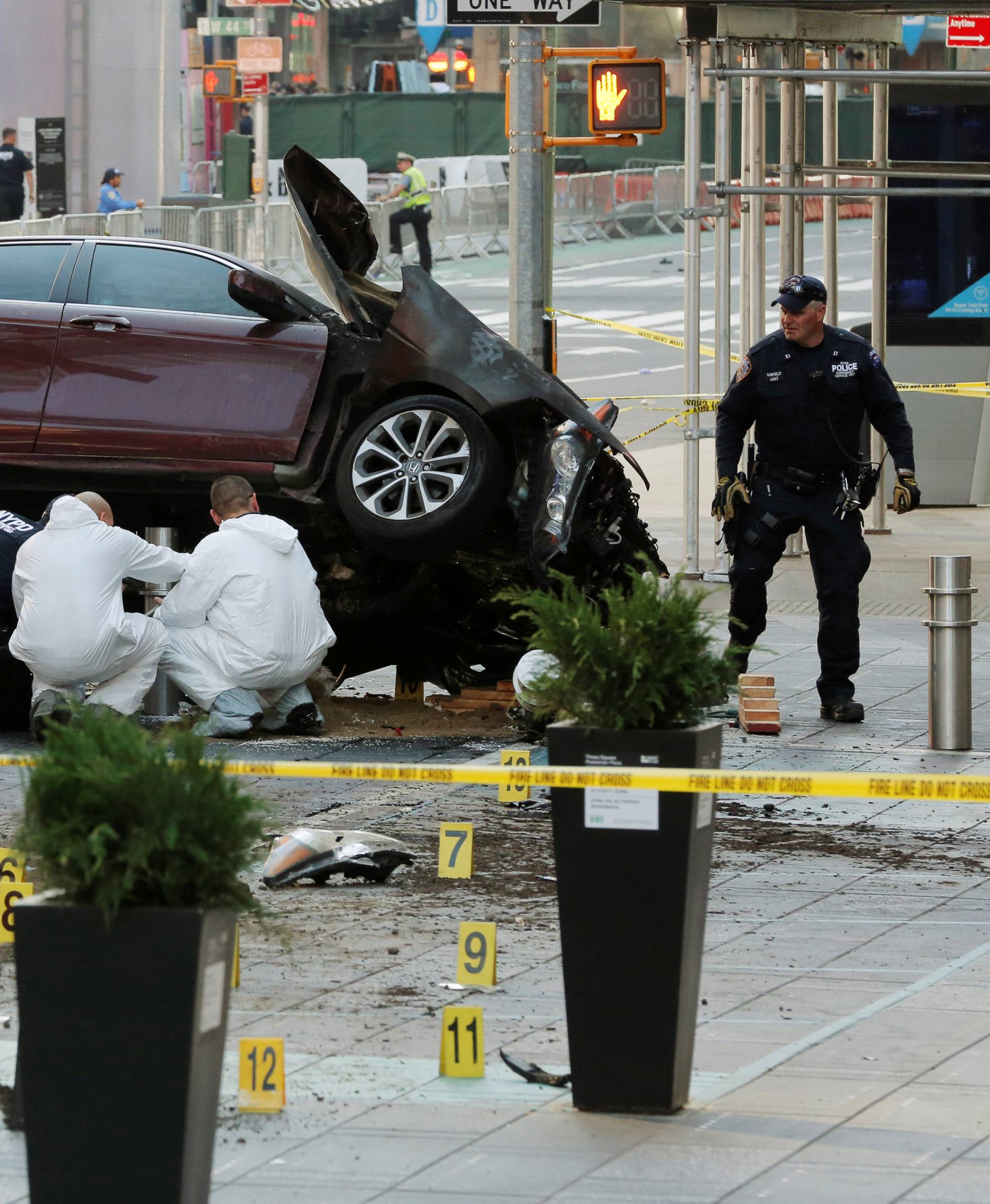 Emergency personnel inspect a vehicle involved in striking a number of pedestrians in Times Square in New York