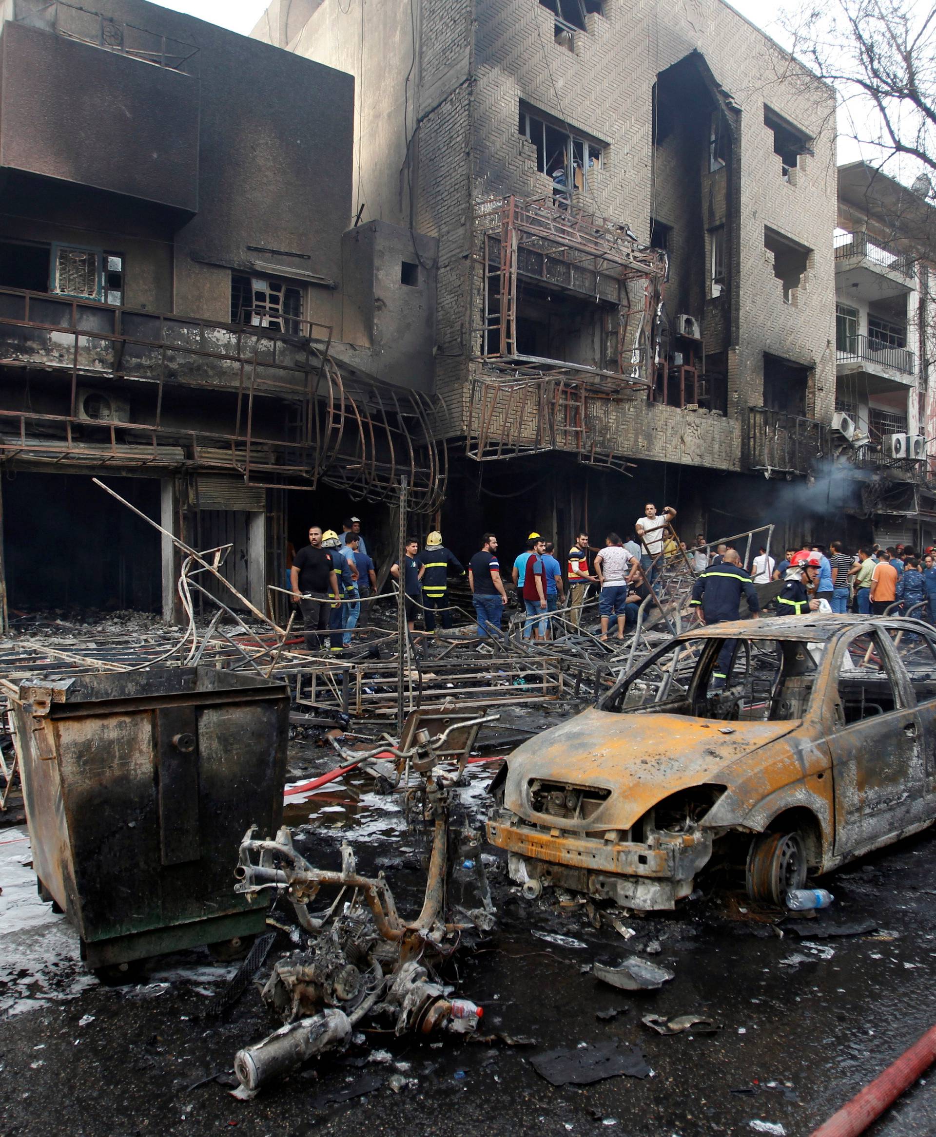 People gather at the site of a suicide car bomb in the Karrada shopping area, in Baghdad, Iraq 