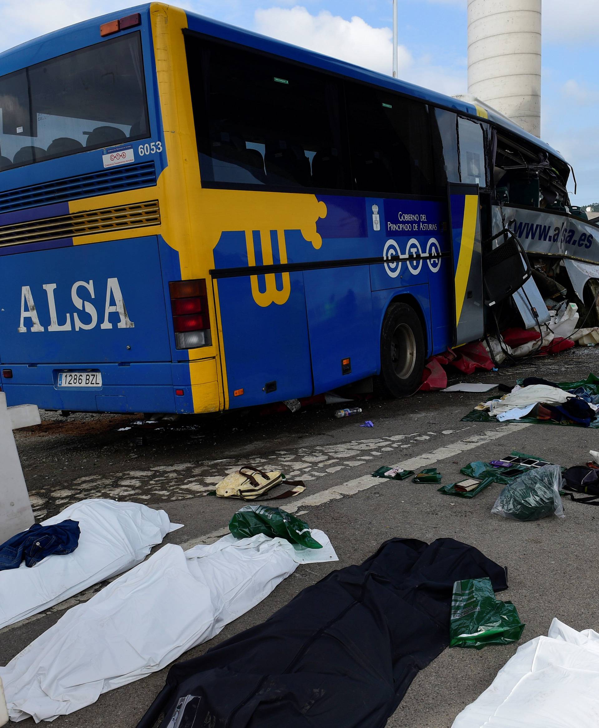Body bags lie at the scene of a bus crash which left at least four people dead in Aviles