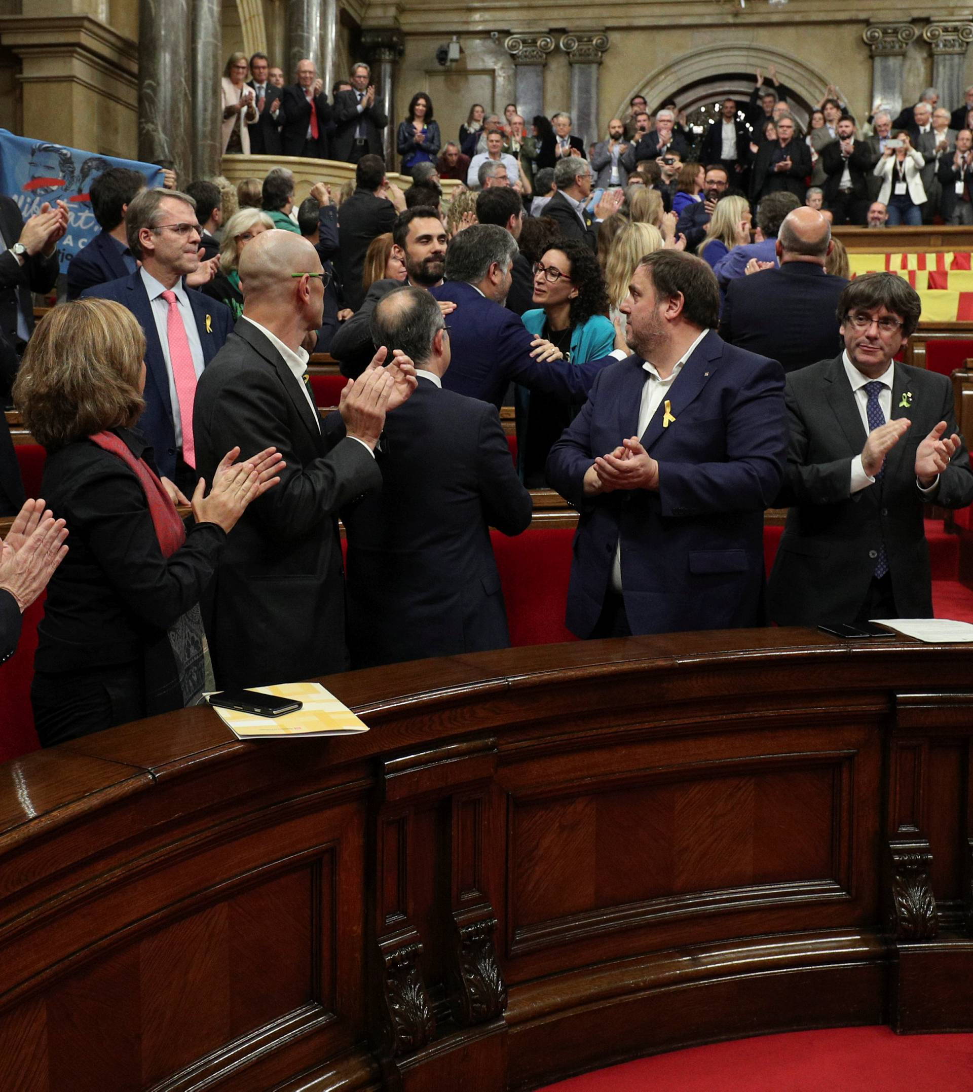 Catalan President Puigdemont and deputies applaud after the Catalan regional Parliament declared indpendence from Spain in Barcelona