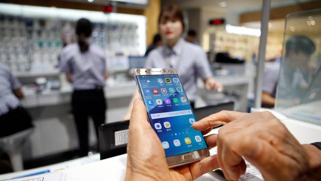 A customer uses his Samsung Electronics' Galaxy Note 7 as he waits for exchange at company's headquarters in Seoul