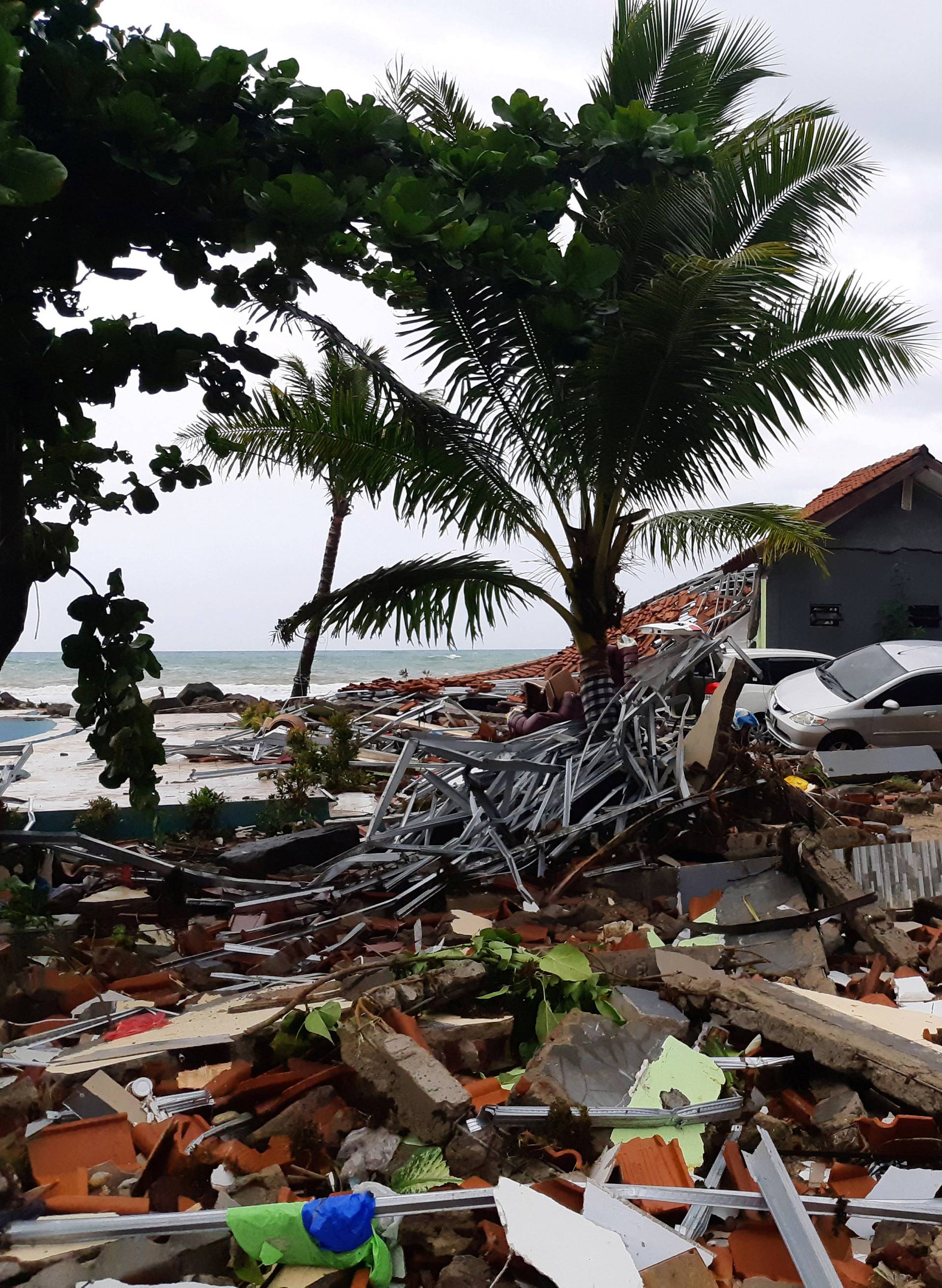 A car is seen among ruins after a tsunami hit Carita beach in Pandeglang, Banten province