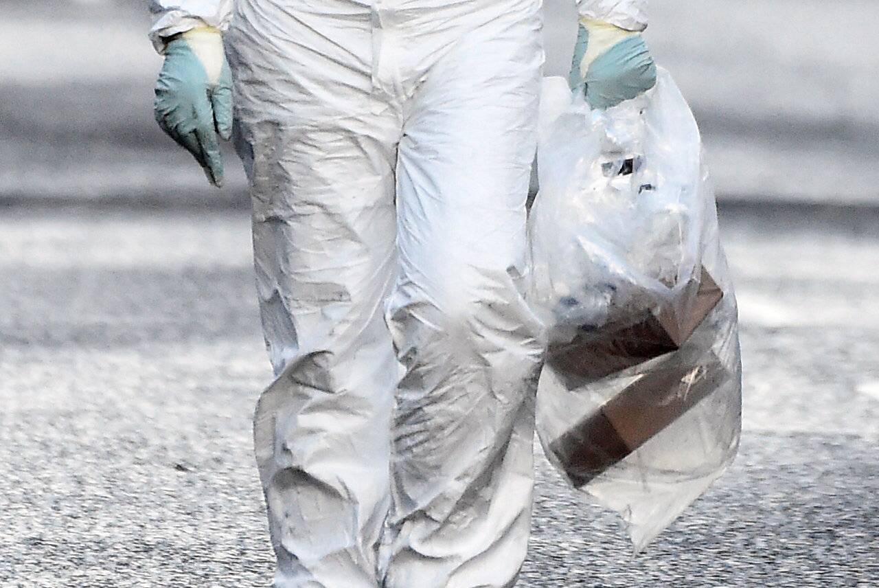 Forensic officer carries a bag of evidence from the scene of a suspected car bomb in Londonderry