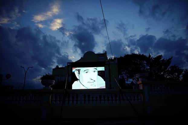 A screen outside a restaurant displays images of late Cuban President Fidel Castro in a state building in Havana