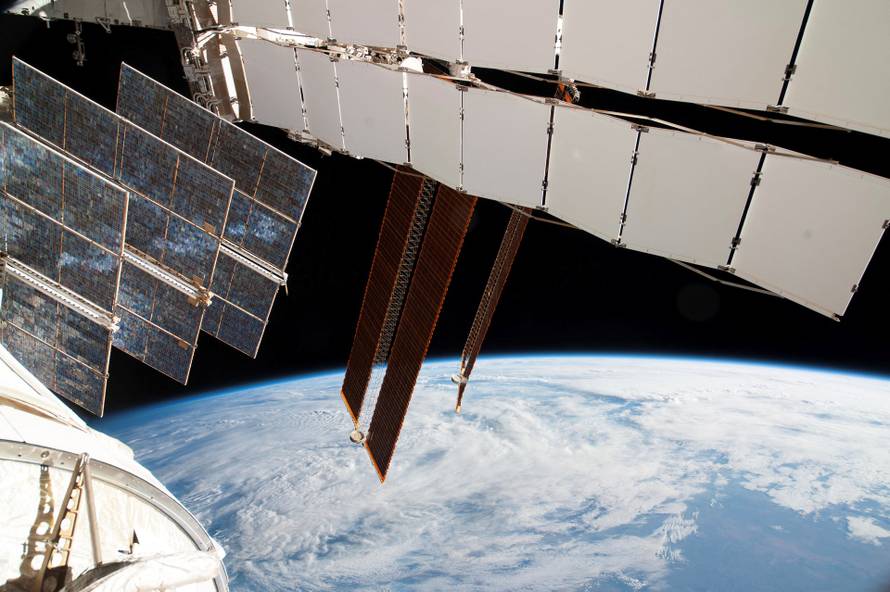 FILE PHOTO: NASA photo of Solar array panels on the Russian segment of the International Space Station and a blue and white part of Earth