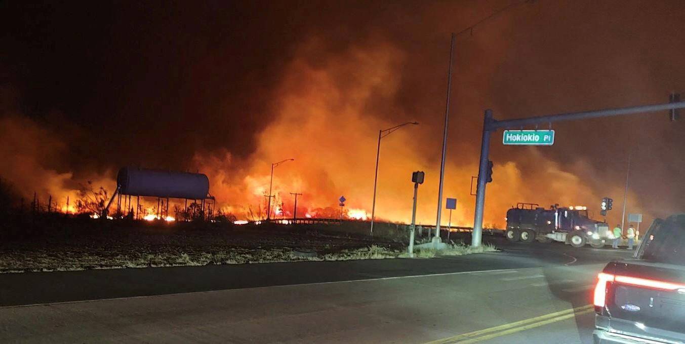 A wildfire burns near an intersection in Lahaina