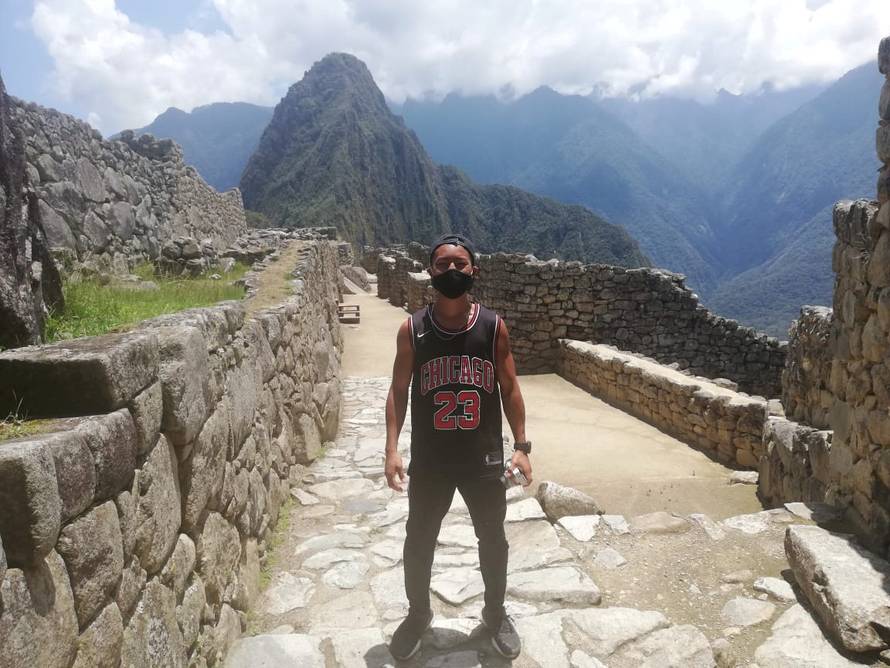 Japanese tourist Jesse Katayama poses for a photograph during his visit to the ruins of Machu Picchu