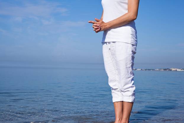 Yoga woman doing exercises at the seafront.