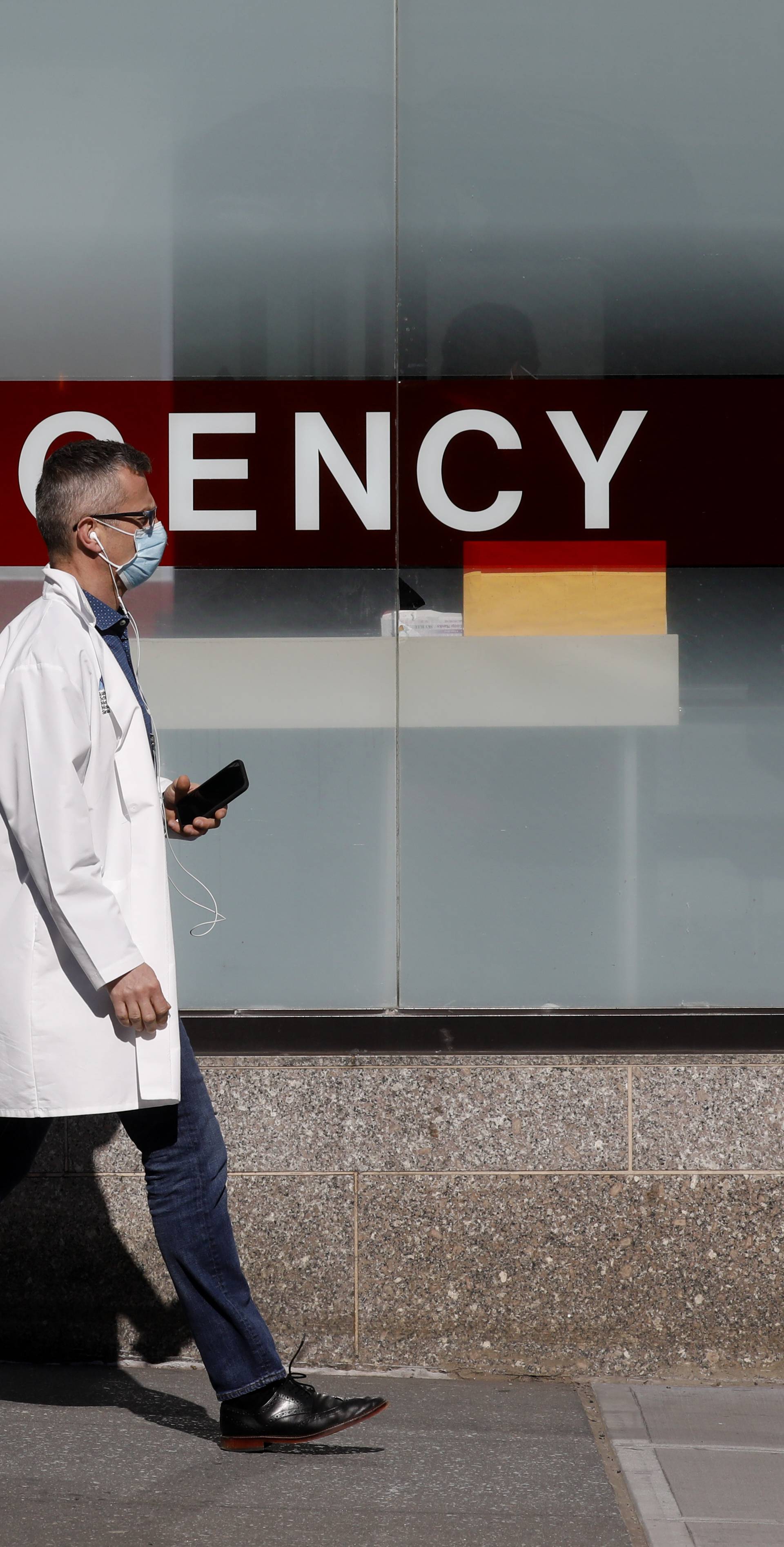 A doctor wears a protective mask as he walks outside Mount Sinai Hospital during the outbreak of coronavirus disease (COVID-19) in New York