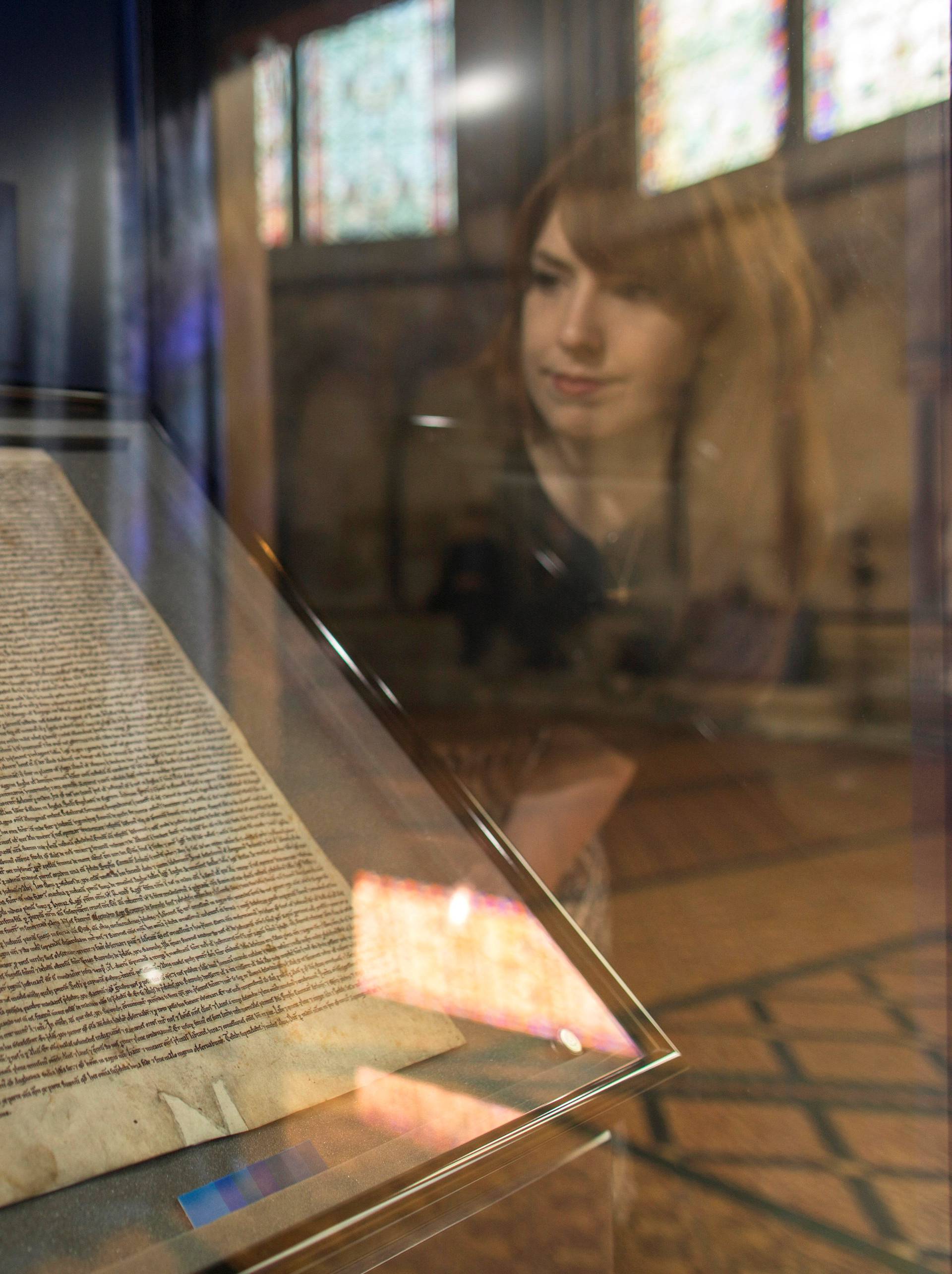FILE PHOTO: Meg Bullock of Salisbury Cathedral poses for photographers as she looks at the Salisbury Magna Carta, one of the original four remaining Magna Carta documents, at Salisbury Cathedral in Salisbury