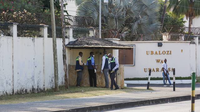 Tanzanian security officers guard an entrance to the French embassy after an attacker wielding an assault rifle was killed in the Salenda area of Dar es Salaam