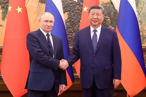 Chinese President Xi Jinping shakes hands with Russian President Vladimir Putin at the Great Hall of the People, in Beijing