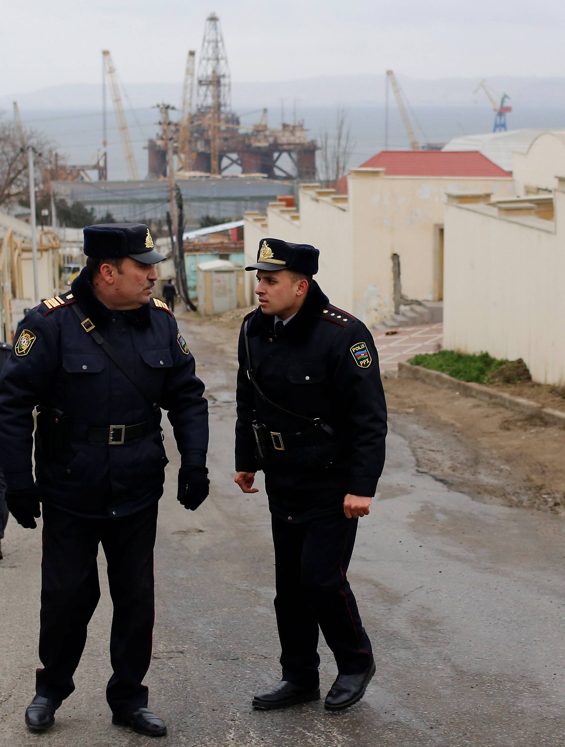 Police officers block a road near the scene of a fire which broke out in a drug abuse treatment center in Baku