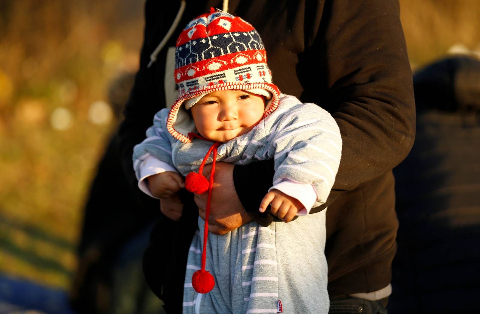 A migrant child is held near Turkey's Pazarkule border crossing with Greece's Kastanies, near Edirne