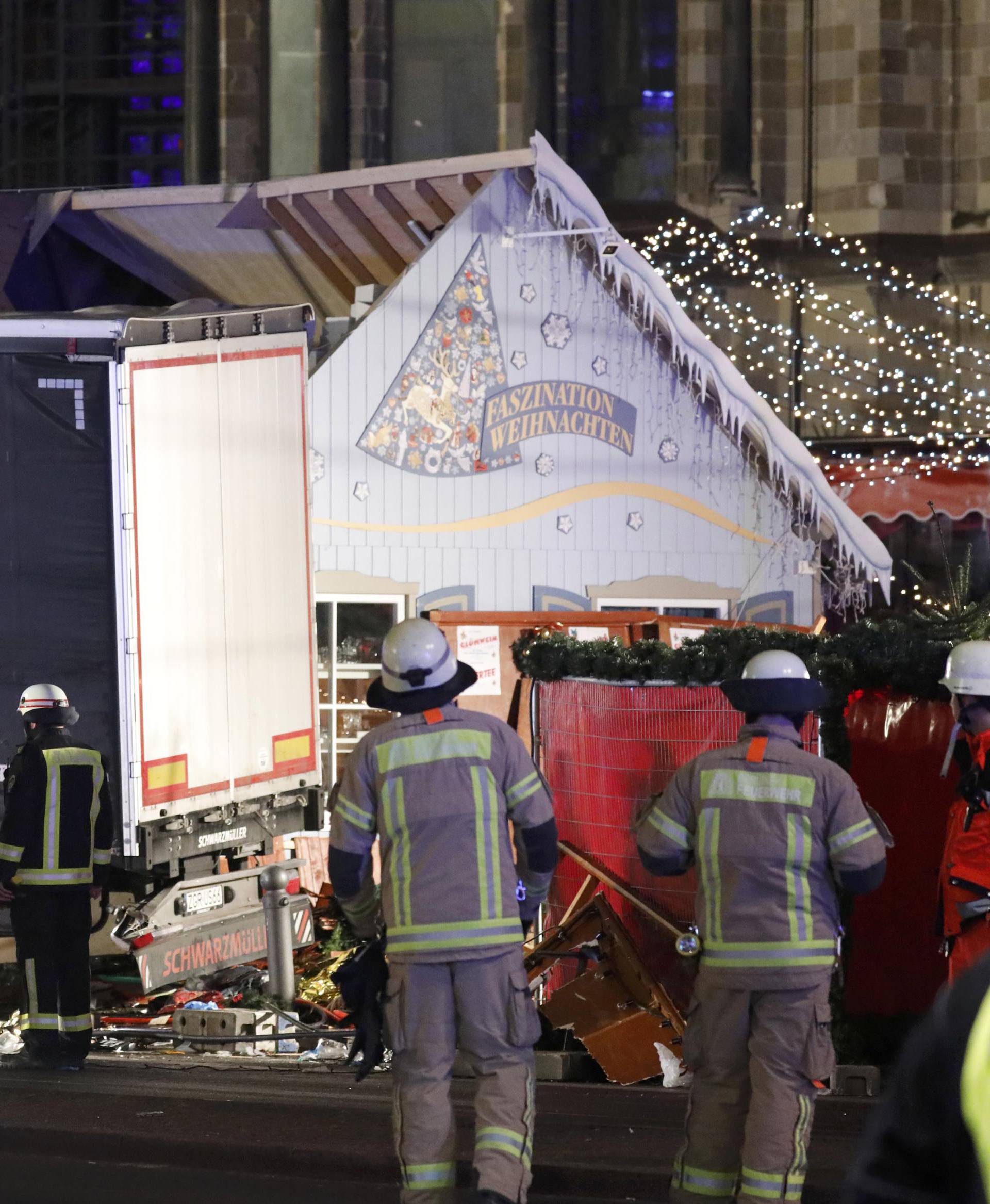 Firefighter stand beside a truck at a Christmas market in Berlin