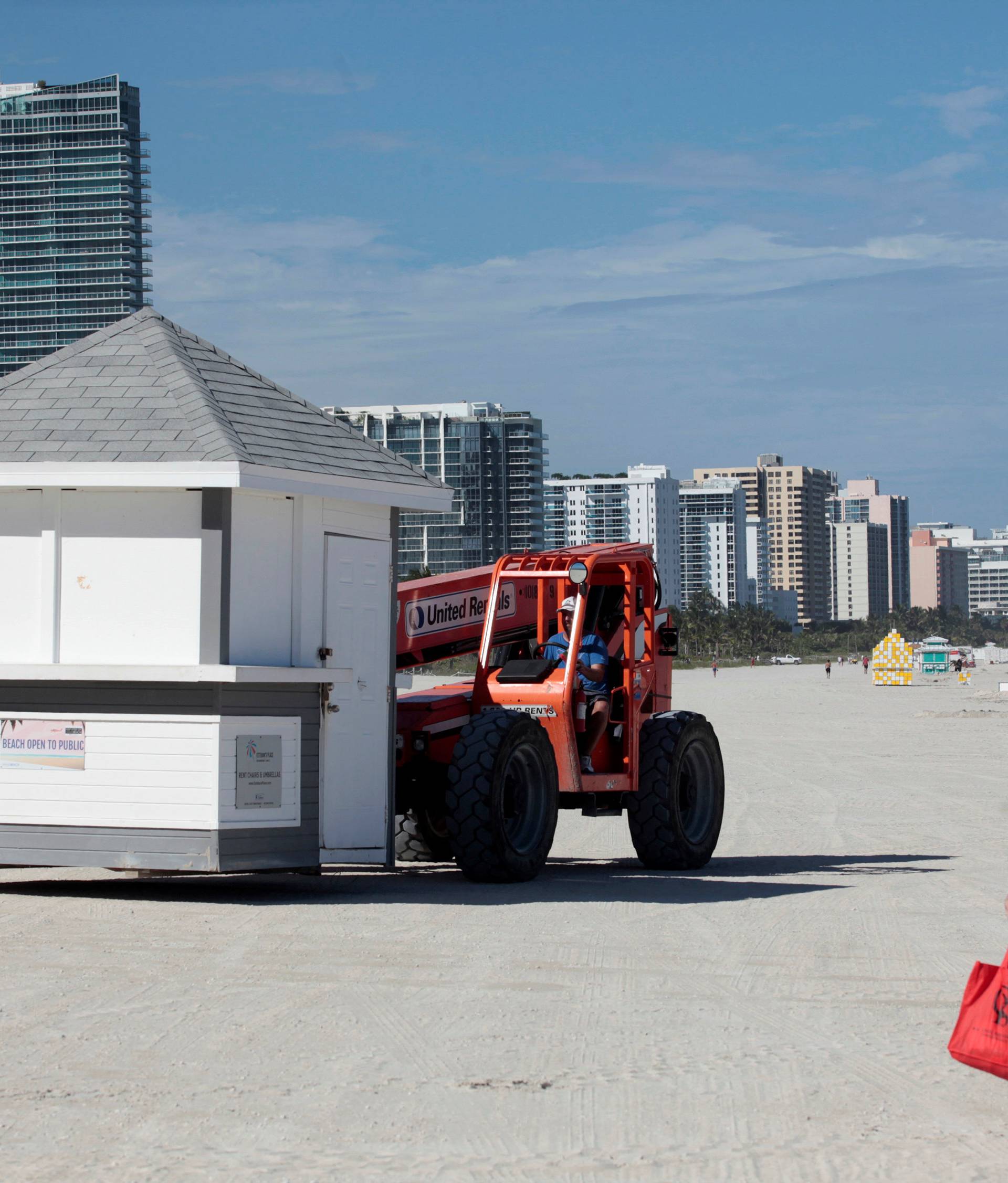 A worker removes a kiosk in anticipation of Hurricane Matthew in Miami Beach