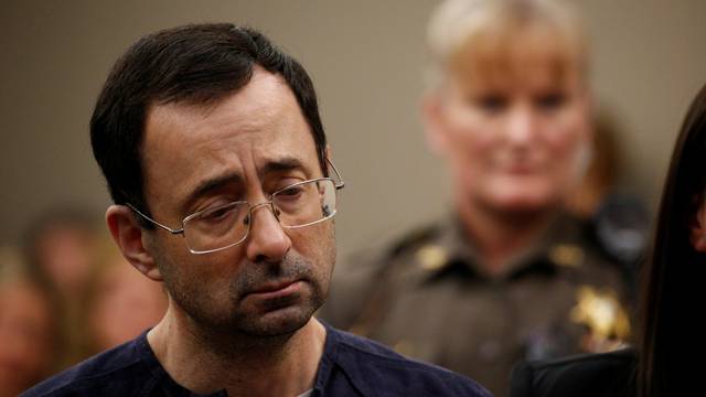 Larry Nassar, a former team USA Gymnastics doctor who pleaded guilty in November 2017 to sexual assault charges, stands during his sentencing hearing in Lansing