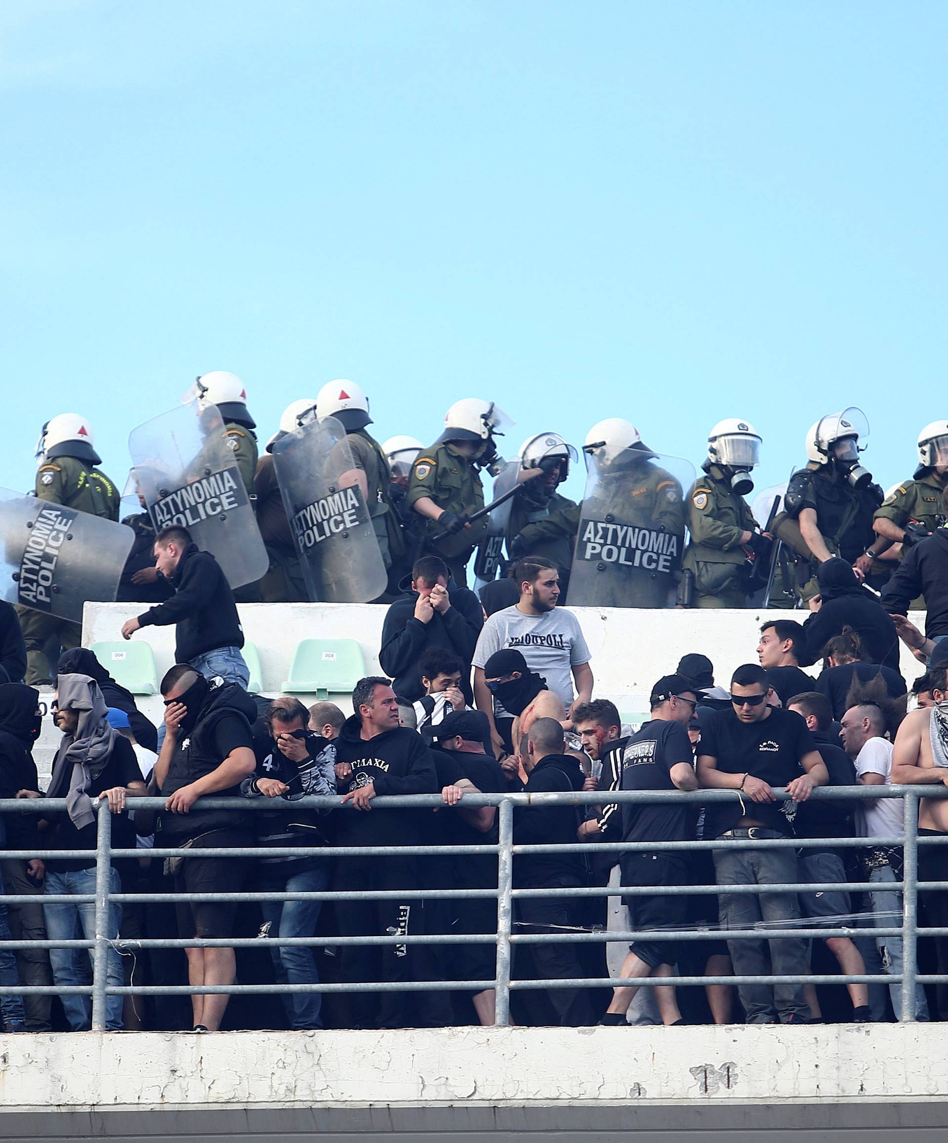 Riot police arrive to push back fans of PAOK Salonika as they clash with fans of AEK Athens before the Greek Cup Final soccer game at Panthessaliko stadium in Volos