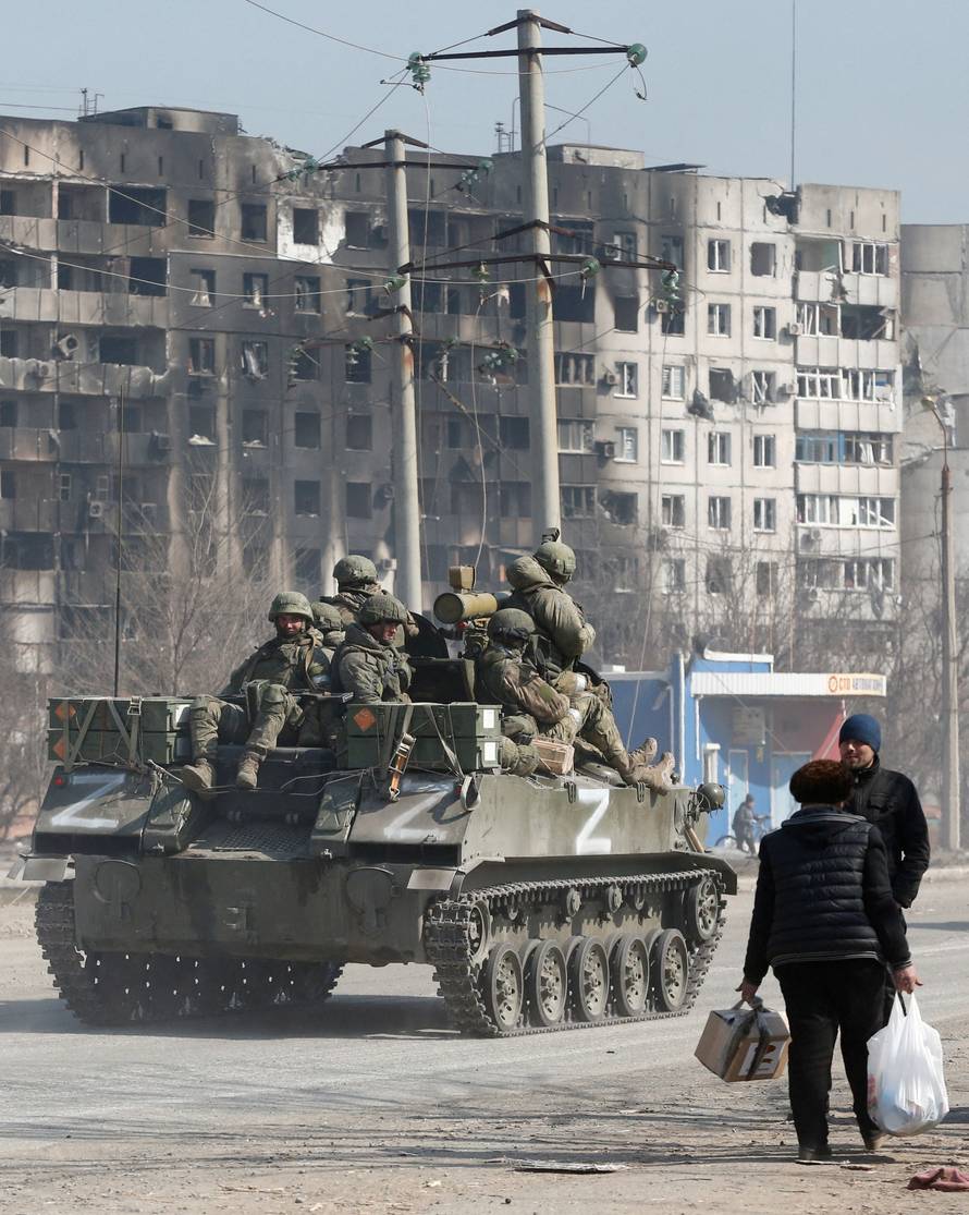 FILE PHOTO: Service members of pro-Russian troops are seen atop of an armoured vehicle in the besieged city of Mariupol