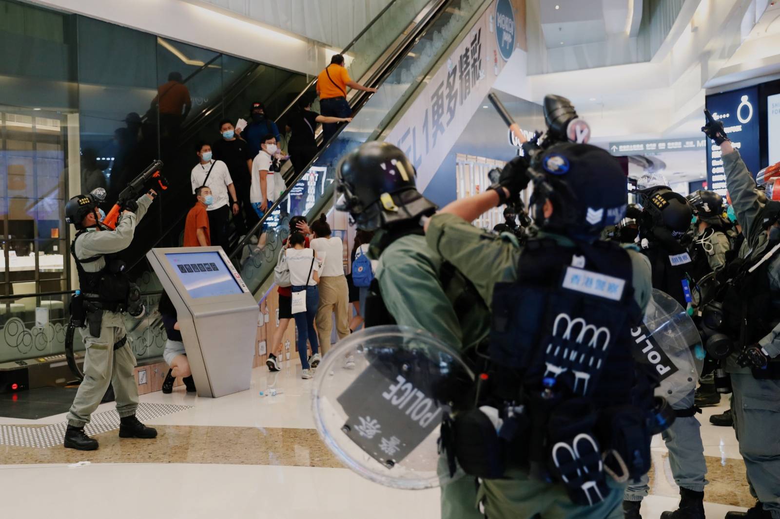 Riot police raise their pepper spray projectile inside a shopping mall as they disperse anti-government protesters during a rally, in Hong Kong