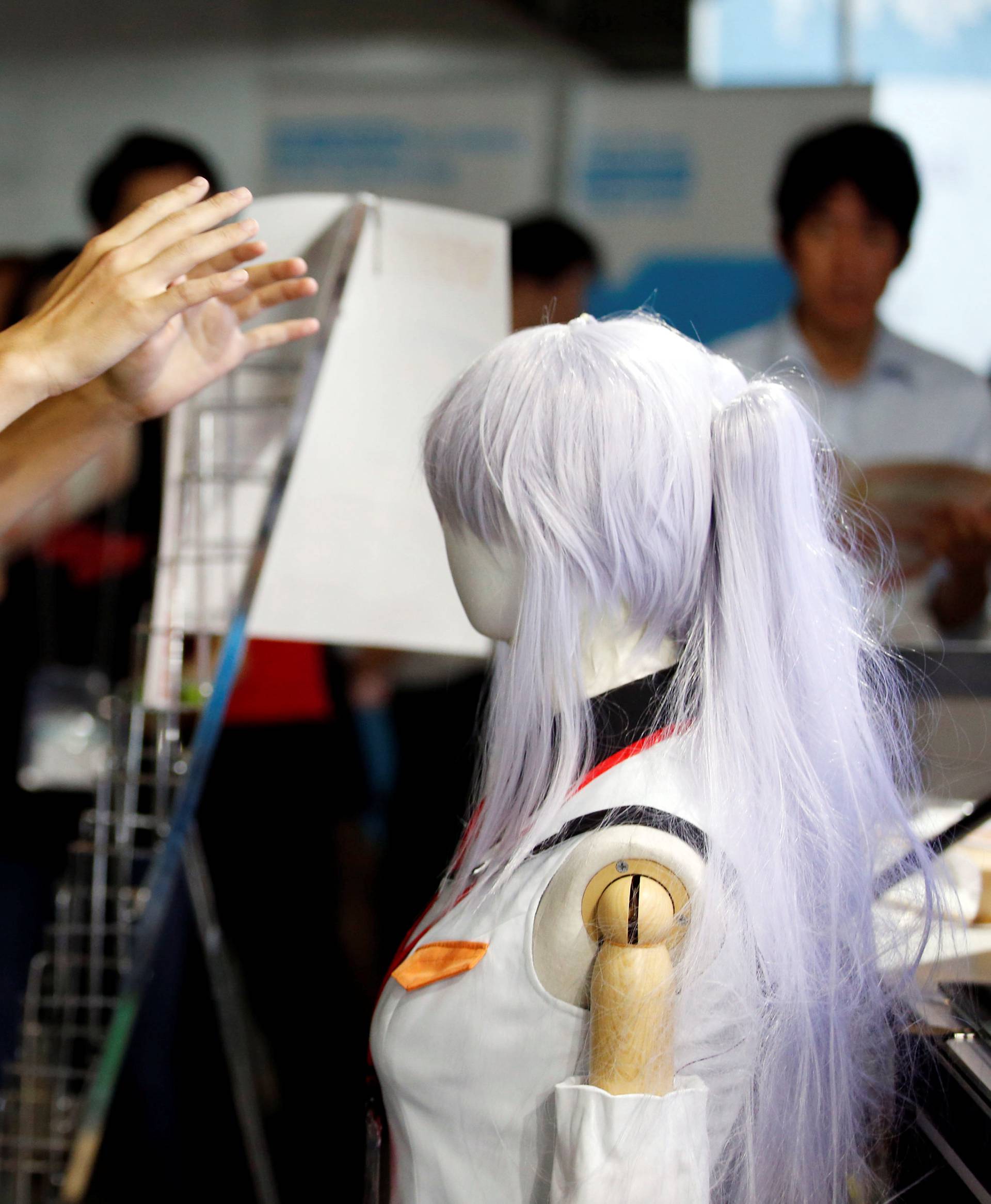 A man rects as he tries out a M2 Co.Ltd's "E-mote" system at Tokyo Game Show 2016 in Chiba