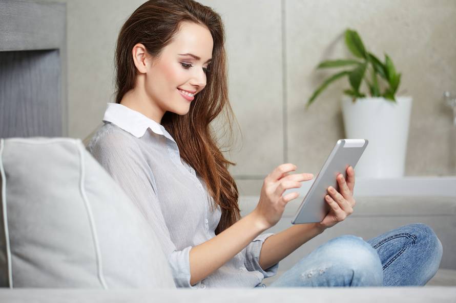 Woman using a laptop while relaxing on the couch