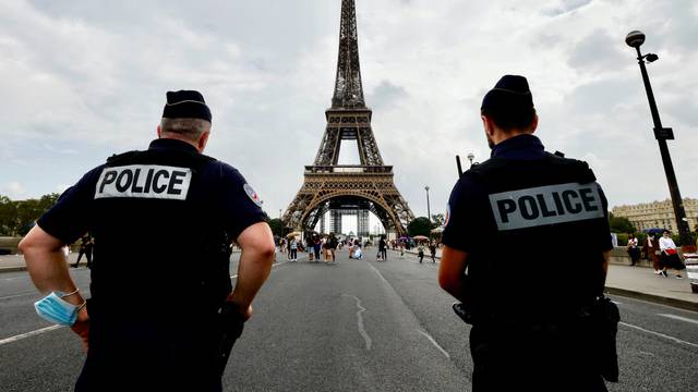 French police officers stand guard in front of the Eiffel tower in Paris