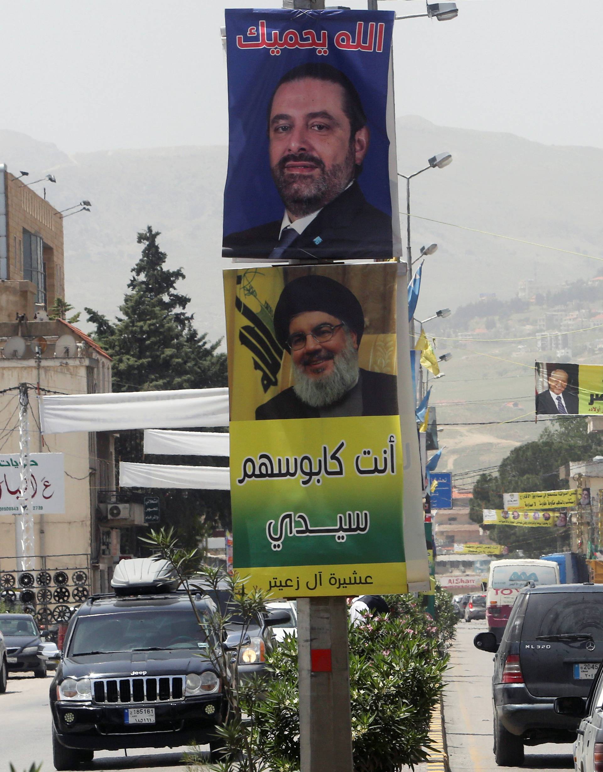 Posters of Lebanese Prime Minister and candidate for parliamentary election Saad al-Hariri and Lebanon's Hezbollah leader Sayyed Hassan Nasrallah hang along a street in Zahle