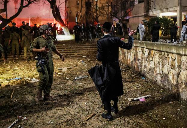 An Israeli soldier secures the impact site after Iranian missile barrages struck residential buildings in Arad, amid the U.S.-Israel conflict with Iran, in southern Israel