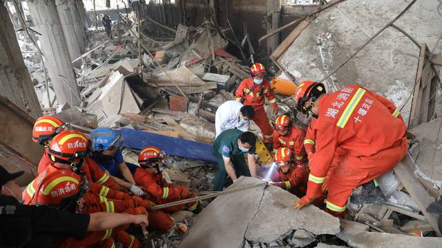 Rescue workers search for victims amid the debris following a gas pipeline explosion in Shiyan