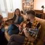 Group of friends on a house party playing guitar and enjoying music