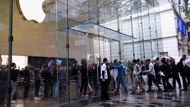 Apple Store staff greets customers who have been waiting in line to purchase Apple's new iPhone XS and XS Max at the Apple Store in Tokyo