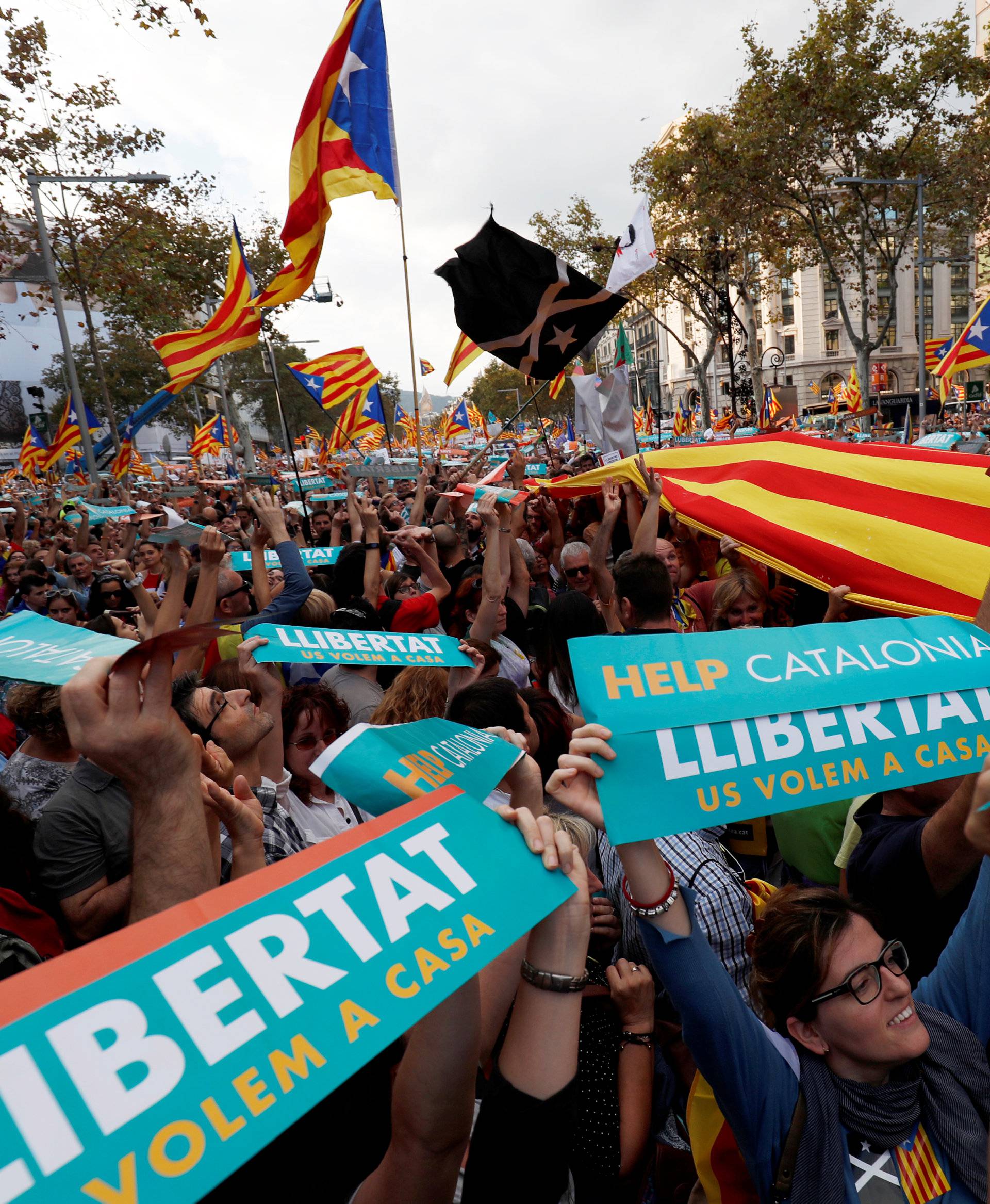 People hold up banners and flags during a demonstration organised by Catalan pro-independence movements ANC (Catalan National Assembly) and Omnium Cutural, following the imprisonment of their two leaders, in