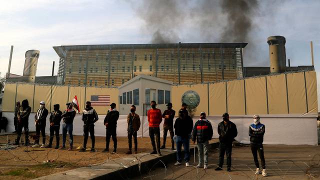 Supporters of Hashd al-Shaabi (Popular Mobilization Forces) burn a large printed image of the U.S. Embassy, in Baghdad