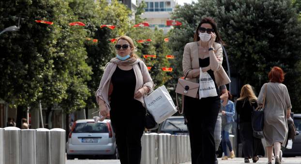 FILE PHOTO: Women wearing masks walk on a street after Prime Minister Dusko Markovic declared the country the coronavirus disease (COVID-19)-free in Podgorica