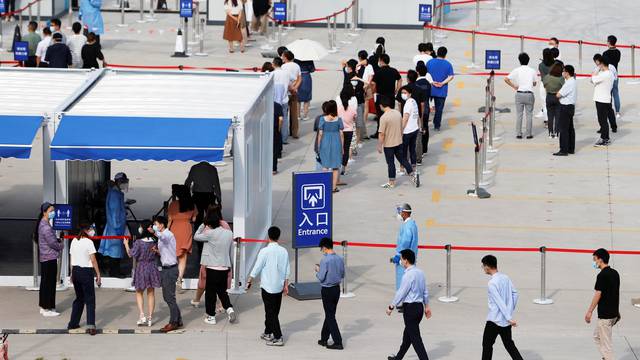 Staff members of Shanghai Pudong International Airport line up for nucleic acid testing in Shanghai