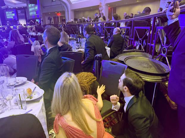 Guests watch from tables after U.S. President Donald Trump and first lady Melania Trump were rushed out of the White House Correspondents' Association dinner