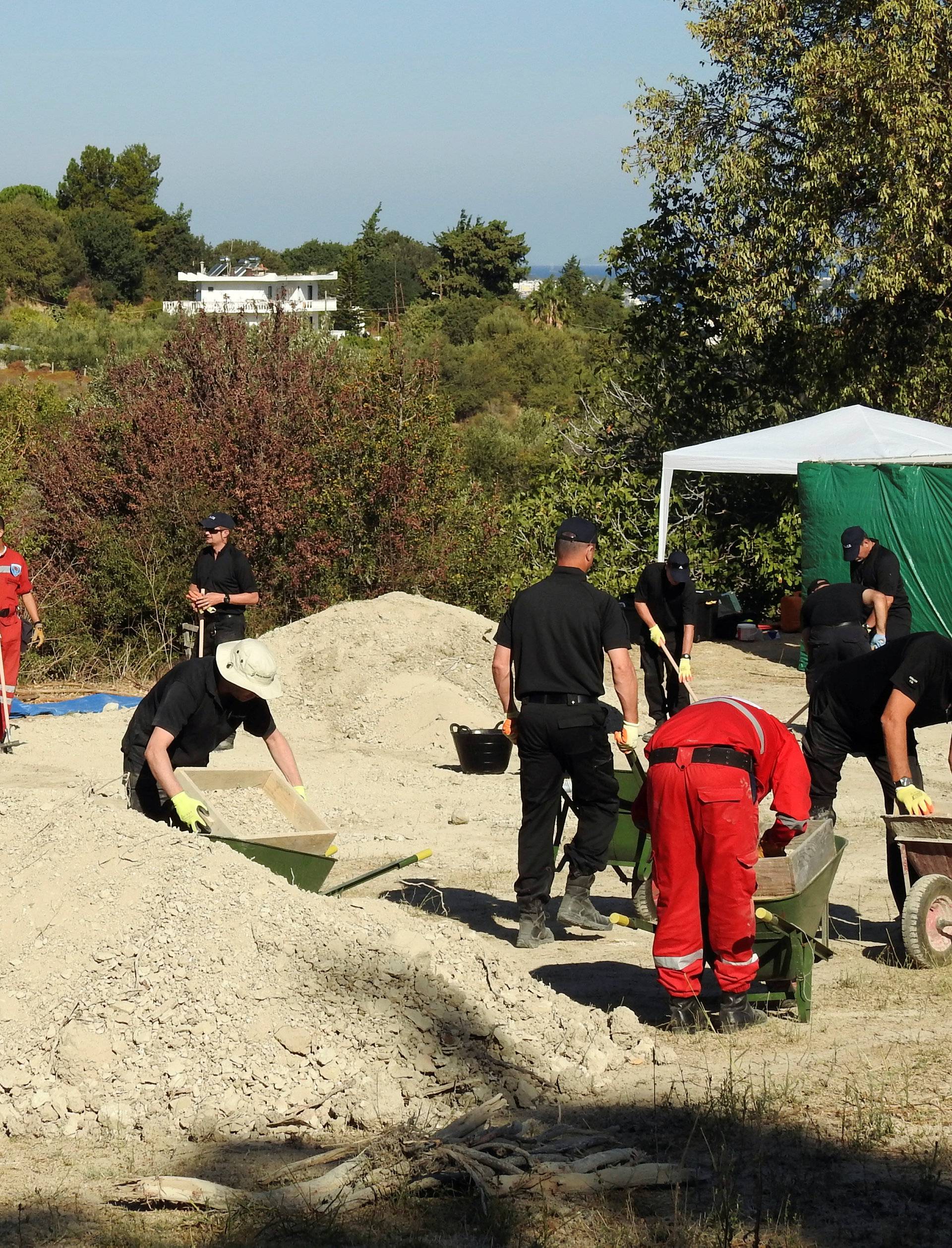 South Yorkshire police officers and members of the Greek rescue service investigate the ground while excavating a site during an investigation for Ben Needham on the island of Kos