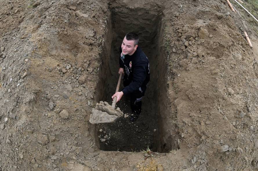 A gravedigger competes during a grave digging championship in Trencin, Slovakia