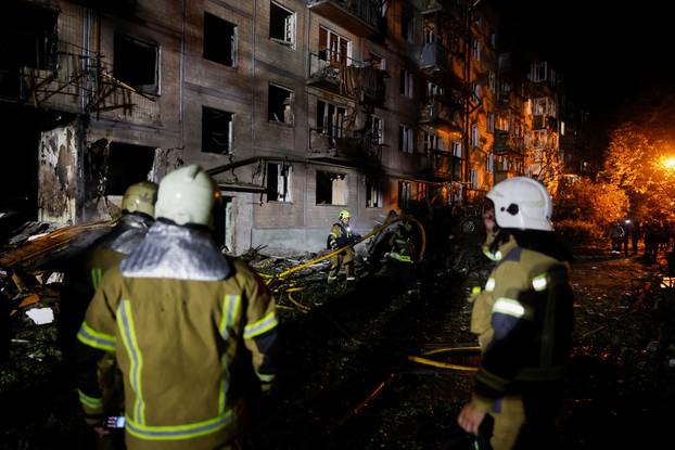 Firefighters work at the site of an apartment building hit by a Russian missile strike in Kyiv